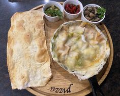 a wooden plate topped with food on top of a table