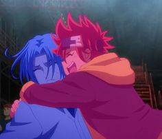 two anime characters hugging each other in front of an audience