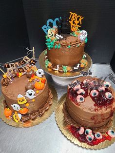 three decorated cakes sitting on top of a table