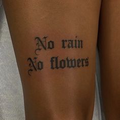 a woman with a tattoo on her leg that says no rain, no flowers written in cursive font