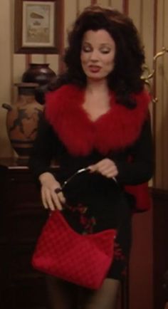 a woman in a red and black dress holding a purse