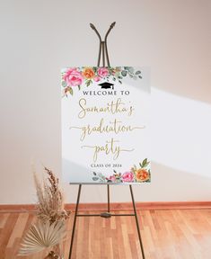 a welcome sign with flowers on it in front of a white wall and wooden floor