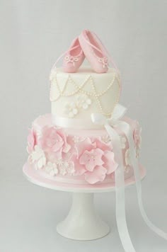 a three tiered cake with pink shoes on top