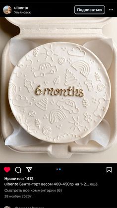 a white plate with gold lettering on it sitting in a box next to other items