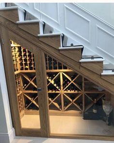 a wine cellar under the stairs in a house