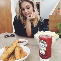 a woman sitting at a table with some food