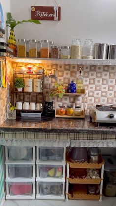 a small kitchen with lots of food on the counter and storage bins under it