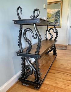 a black shelf with two shelves on top of it in the corner of a room