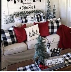 a living room decorated for christmas with black and white plaid pillows on the couches