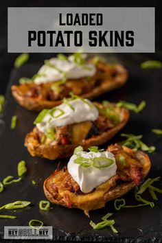 loaded potato skins with sour cream and scallions on top, sitting on a black plate