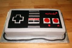 a cake that is shaped like a video game controller on top of a wooden table