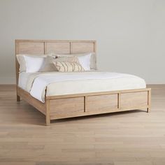 a bed sitting on top of a hard wood floor next to a white wall and wooden floors