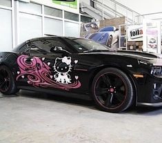 a black car with pink and white designs on it