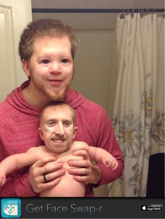 a man holding a baby in front of a mirror with the caption get face swap