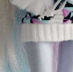 a close up of a person's leg wearing white socks and a sweater with feathers on it