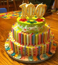 a birthday cake with candles on it and the words 100 is written in large letters