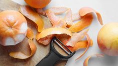 peeled oranges on a cutting board with a knife