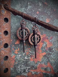 Layered antiqued copper rings with steel internal tooth lock washer, verdigris pendant and antique iron mason nail. Cotton cord and steel wire wrap detail. On 20 gauge oxidized copper ear wires. Approximately 3 inches in length from top of ear hook to end of nail. Weigh 0.3 oz per earring Rustic Bronze Patina Earrings, Rustic Bronze Earrings With Patina, Rustic Brass Earrings With Patina, Gothic Bronze Jewelry With Antique Finish, Bronze Brass Jewelry For Larp, Antique Metal Jewelry With Patina, Medieval Style Bronze Jewelry With Antique Finish, Medieval Bronze Jewelry With Antique Finish, Gothic Oxidized Metal Earrings