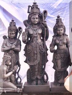 there are three statues on display in front of a woman holding an umbrella and another statue behind her