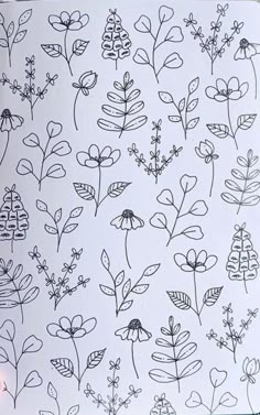 a sheet of paper with black and white flowers on it, next to a pen