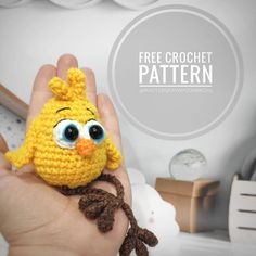 a hand holding a small crocheted yellow bird