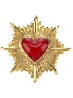 a gold and red heart brooch with sunbursts on the side,