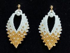 two pairs of white and gold beaded earrings with pearls hanging from the ends on a black background