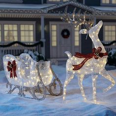 two lighted reindeer pulling a sleigh in the snow