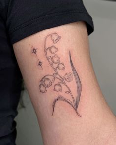 a small flower tattoo on the back of a woman's left leg, with stars in the background