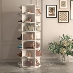 a white shoe rack with many pairs of shoes on it in front of a potted plant