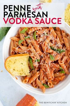 penne with parmesan vodka sauce in a white bowl next to a piece of bread