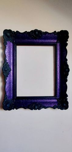 a purple and black frame hanging on the wall