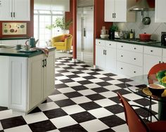 a kitchen with black and white checkered flooring next to a dining room table