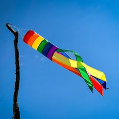 a colorful kite is flying high in the sky on a sunny day with no clouds