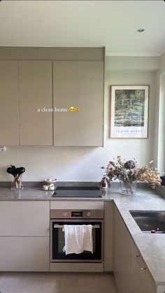 a clean kitchen with white cabinets and gray counter tops is seen in this image from the front view