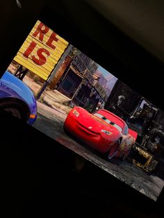 cars are shown on the screen in front of a movie sign