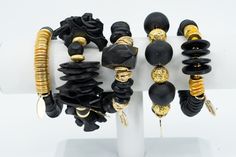 Black African Recycled Glass, Bone, Lava Rock & Horn Bead Bracelets with Gold Accents. Chic and Glamorous African Inspired Jewelry that is versatile enough to take you from the Beach to the Boardroom and from Summer through Winter. Coastal Beach BoHo influence Stacked Bracelet Set For Women. Each bracelet can be worn alone or together for a stunning look.  Bracelet Styles 1.  Black bone, recycled glass and lava rock beads with gold accent. 2.  Black recycled glass and lava rock beads accented with gold lava rock beads. 3.  Black coconut chips and recycled glass beads with gold accent. 4.  Black vinyl disk beads accented with gold disk beads. 5.  Black bone disk and recycled glass beads accented with gold. If you would like a more detailed description, please message me.  All bracelets are Afro Jewelry, African Beaded Bracelets, African Inspired Jewelry, Afrocentric Jewelry, Bracelet Styles, Coconut Chips, Recycled Glass Bead, Handmade Market, Beach Boho