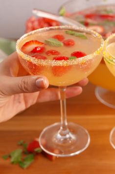 two glasses filled with drinks sitting on top of a wooden table