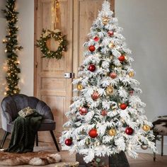 a white christmas tree with red and gold ornaments