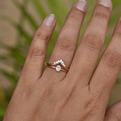 a woman's hand with a diamond ring on top of her finger and the other hand holding it