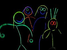 some neon colored figures are standing in the dark