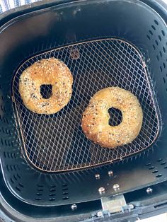 two bagels sitting on top of a fryer in a basket next to each other