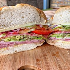 a cut in half sandwich sitting on top of a wooden cutting board