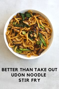 a white bowl filled with noodles and vegetables on top of a table next to the words, better than take out udon noodle stir fry