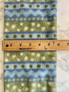 a ruler is next to a green and blue blanket