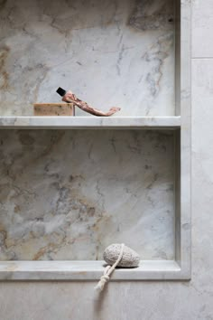 two shelves with different items on them in a marbled room that looks like it has been built into the wall