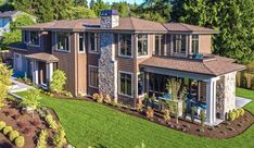 an aerial view of a large home with lots of windows and grass in the front yard