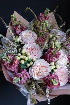 a bouquet of pink and white flowers sitting on top of a table