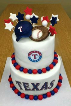 a three tiered cake decorated with red, white and blue decorations on top of a wooden table