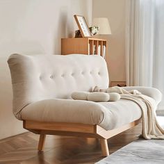 a living room with a white couch and wooden furniture in front of a large window